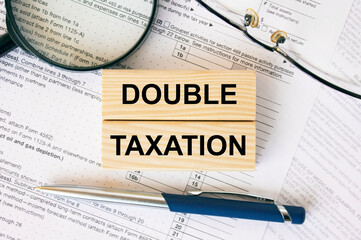 Wooden blocks with text Double Taxation on financial docs