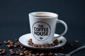 white coffee cup with coffee and beans
