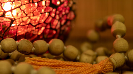 Extreme clos up of wooden buddhist prayer beads also called mala in candle light. Equipment for...