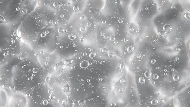 Motion, rotation of the liquid cream gel transparent cosmetic texture with bubbles. Organic cosmetics, medicine. Top view. Slow motion. 