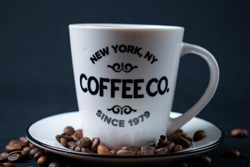 white coffee cup with coffee and beans