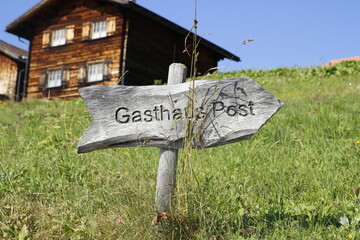 Holzschild: Gasthaus, zeigt nach rechts.Urlaub in der Schweiz.