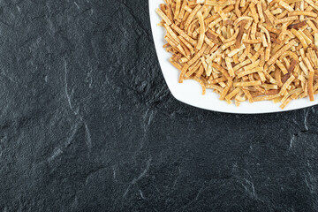 Plate of raw pasta on dark background