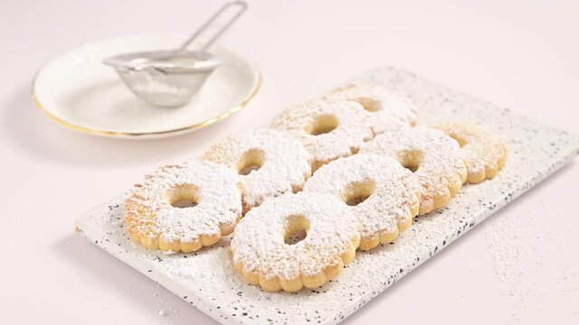 Canestrelli, traditional Ligurian chamomile-shaped cookies with powdered sugar. Holiday baked goods from the south of italy, frolla pasta in hand. Horizontal video