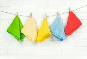 Colorful microfibre rags hang on a string in the kitchen