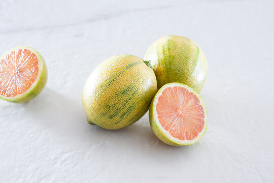 A view of whole and half Variegated pink lemons.