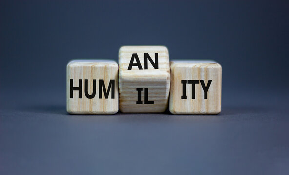 Humility vs humanity symbol. Turned cubes and changed the word 'humility' to 'humanity'. Beautiful grey table, grey background, copy space. Business and humility vs humanity concept.