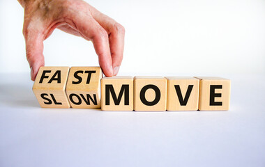 Time to fast move symbol. Businessman turns a wooden cube and changes words 'slow move' to 'fast move'. Beautiful white table, white background, copy space. Business and slow or fast move concept.