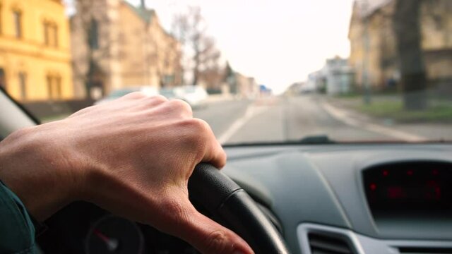 Car movement on the road, view from the car. The driver's hand drives vehicles in motion. Transportation of passengers along the route.