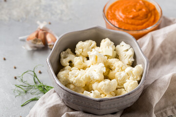 Fresh cauliflower salad in bowl on the table, tomato sauce, healthy food, health concept