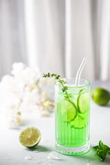 Summer green drink, lemonade with lime, basil and ice in a glass