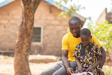 african man teaching a child outdoor