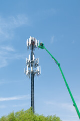 A work crew performs maintenance on a cell phone transmission tower. 
