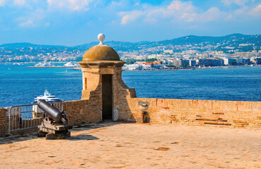Tower and cannon of Fort Royal on Sainte-Marguerite Island. Cannes in opposite shore. Lerins Islands, France