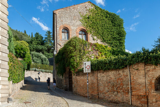 The medieval village of Monselice, walk towards the castle, on a day with blue sky, clouds, detail of the brick buildings of the stone road. Padua, Veneto.Italy.