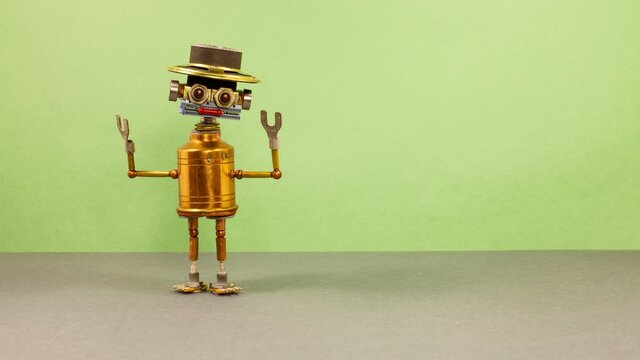 Creative design mechanical copper robot with a funny hat gestures with his hands and shifts shyly. Green gray background. copy space for text