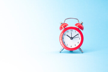 red round analog alarm clock isolated on blue background. time 10:10. space for text.
