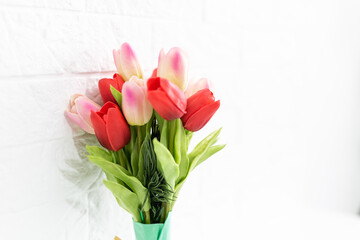 Bouquet of spring tulips with different color flowers wrapped in paper for present on white background