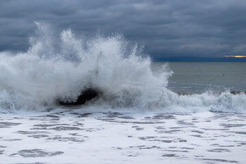 Fototapeta premium waves breaking rock on the beach