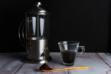 Coffee pot, cup and wooden spoon with coffee