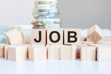 JOB word written on wooden blocks. American currency. Money and financial concept.