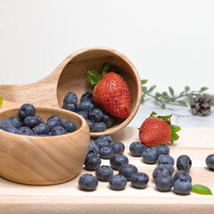 Fresh blueberries and strawberries in a wooden mug. Natural vitamins concept