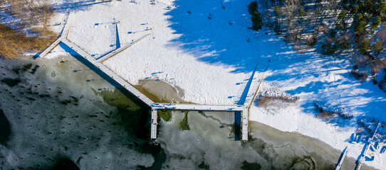 Zimowy widok z lotu ptaka na główną plażę nad skutym lodem jeziorem Głębokie, lubuskie,...