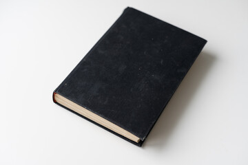 Blank book with black cover on white background.