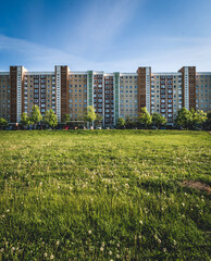 Multi-storey building in a green field against a blue sky and clouds Rostock Germany