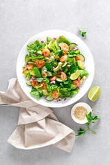 Shrimps salad with green lettuce romen, cucumbers and avocado, dressed with lime juice, healthy and tasty food, top view