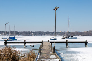 A scene of White Rock Lake in Dallas Texas with sailboats in view after a hard freeze and snow storm in February 2021