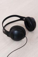 Fototapeta na wymiar Black headphones for listening to music on a wooden table. 