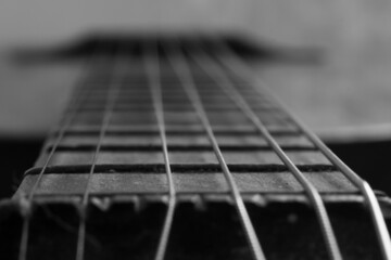 black and white close up photo of an old guitar. Macro photo of guitar strings.
