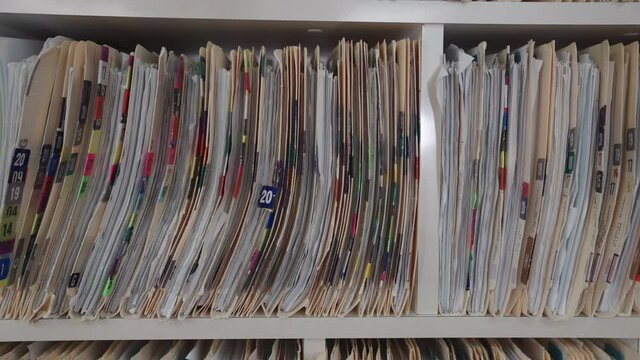 Medical cards on shelves in hospital. Health insurance folders in archive files. Records and catalogs in medicine clinic. Patient healthcare information