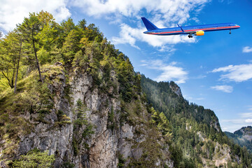 Fototapeta na wymiar A big blue jet flying over beautiful high mountains.