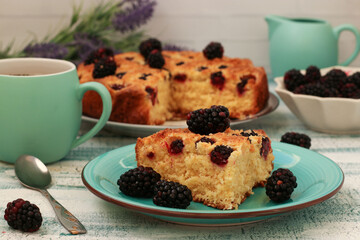 Piece homemade pie with blackberries and coconut chips on a light blue background. Closeup