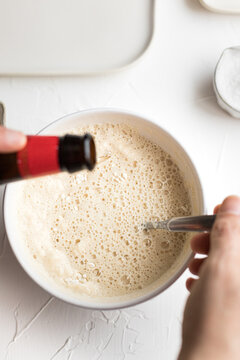 Closeup View Of A Hand Man Stirring Tempura Butter With A Metallic Spoon And Dropping Very Cold Beer On It.