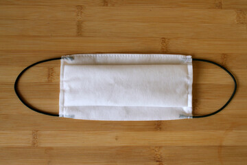 Coronavirus medical mask on wooden texture.