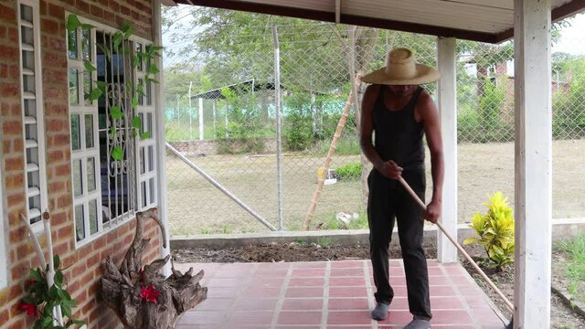 Hombre limpiando su casa con la escoba