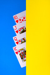Closeup view of some Poker playing Cards over a blue and yellow table
