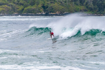 Surfer on Board at Stormy Waves of Beautiful Rocky Coast.