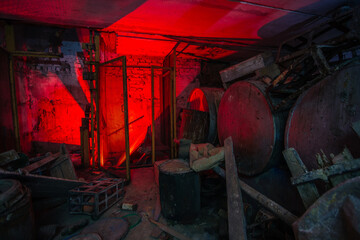Old broken dirty abandoned industrial building basement, illuminated by color lamp