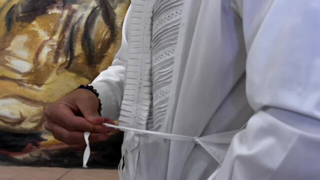 Male bullfighter hands calmly tying his white shirt