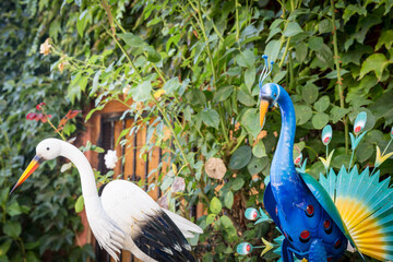 a blue peacock and a stork used for decoration on a garden