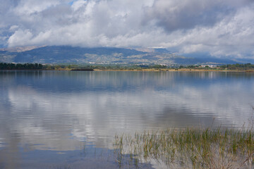 Lake dam landscape with reflection of Gardunha mountains and trees on a cloudy day in Santa Agueda Marateca Dam in Portugal