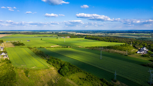 Aerial view of green agricultural fields in summer, nicely covered by shadows from clouds