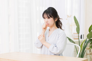 喉に手を当てる若い女性
