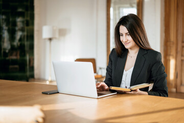 a financier is a business woman working on a computer. opens the laptop and prints a message to colleagues. the lawyer in the company for Finance in the Bank. Modern office
