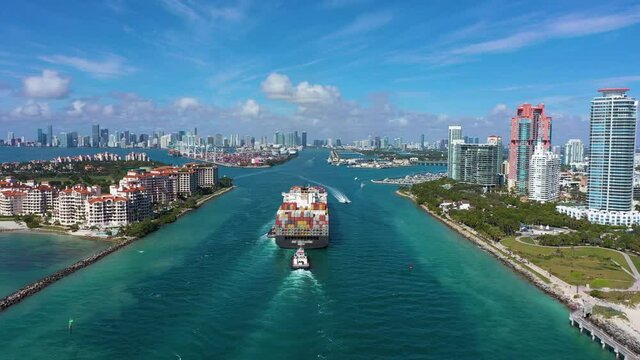 Large Container Ship Entering Port of Miami, USA. City on Sunny Day. Aerial View. Drone Flies Forward