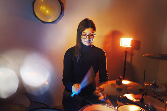 Adult Caucasian Woman Drummer Playing In Dark Room At Home Or Studio - Female Practice Rhythm On Drum Set Music Playing